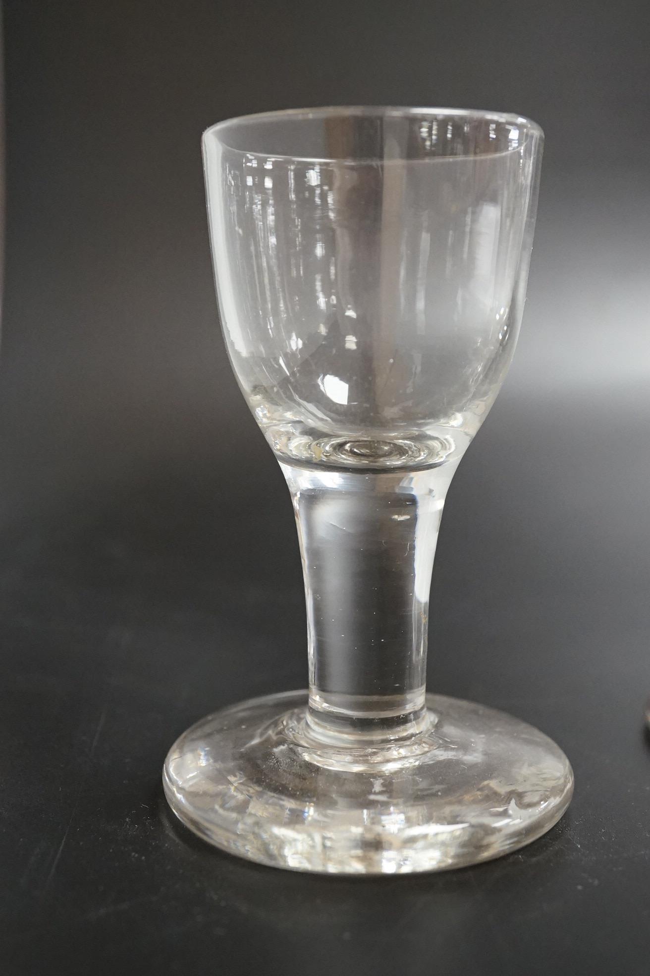 Two George III firing glasses, one with DSOT stem, together with a gin glass with engraved bowl, tallest 11.5cm high (3)